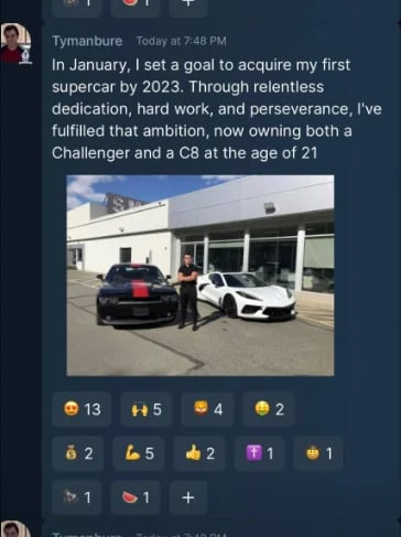 Young man posing between black and white sports cars at dealership